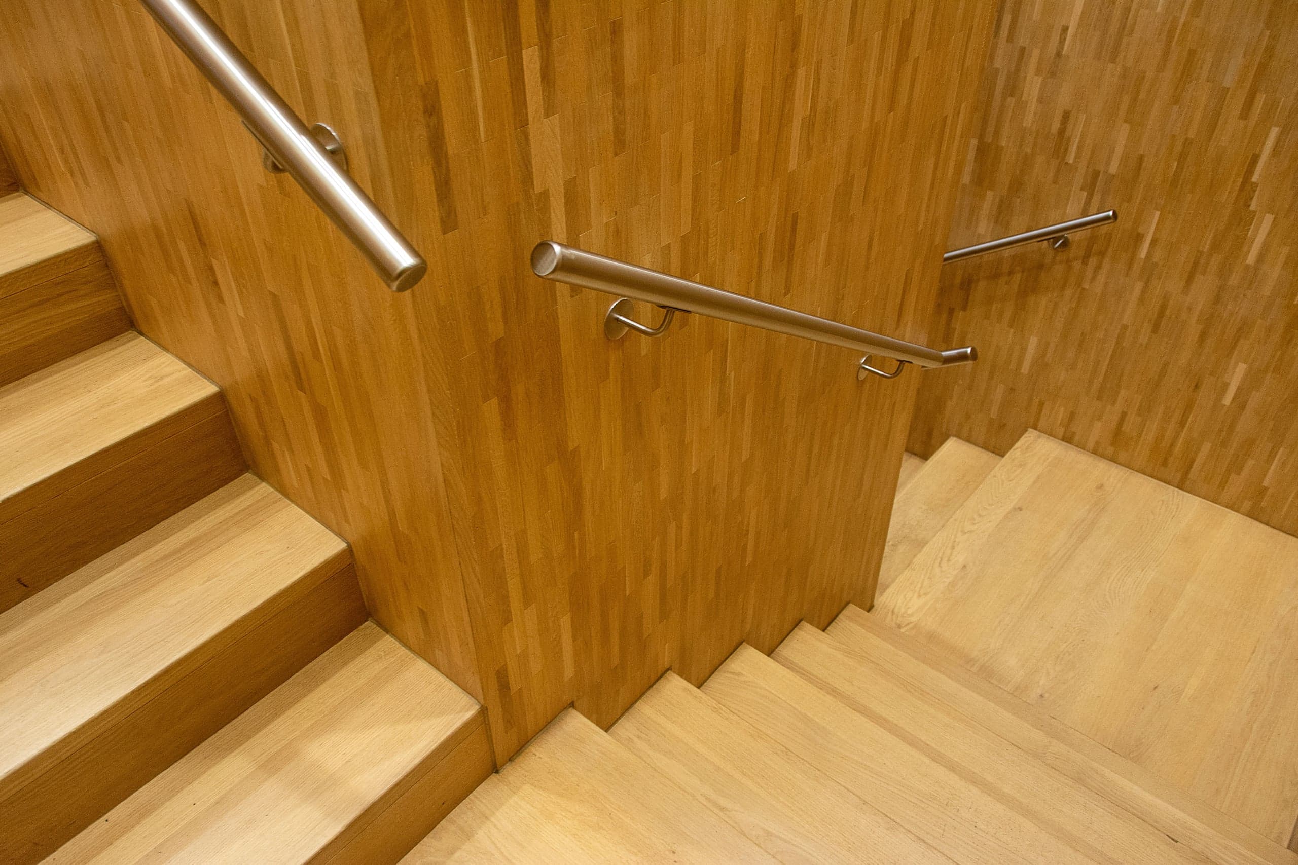 Escalier en chêne clair vu d'en haut, main courante en métal