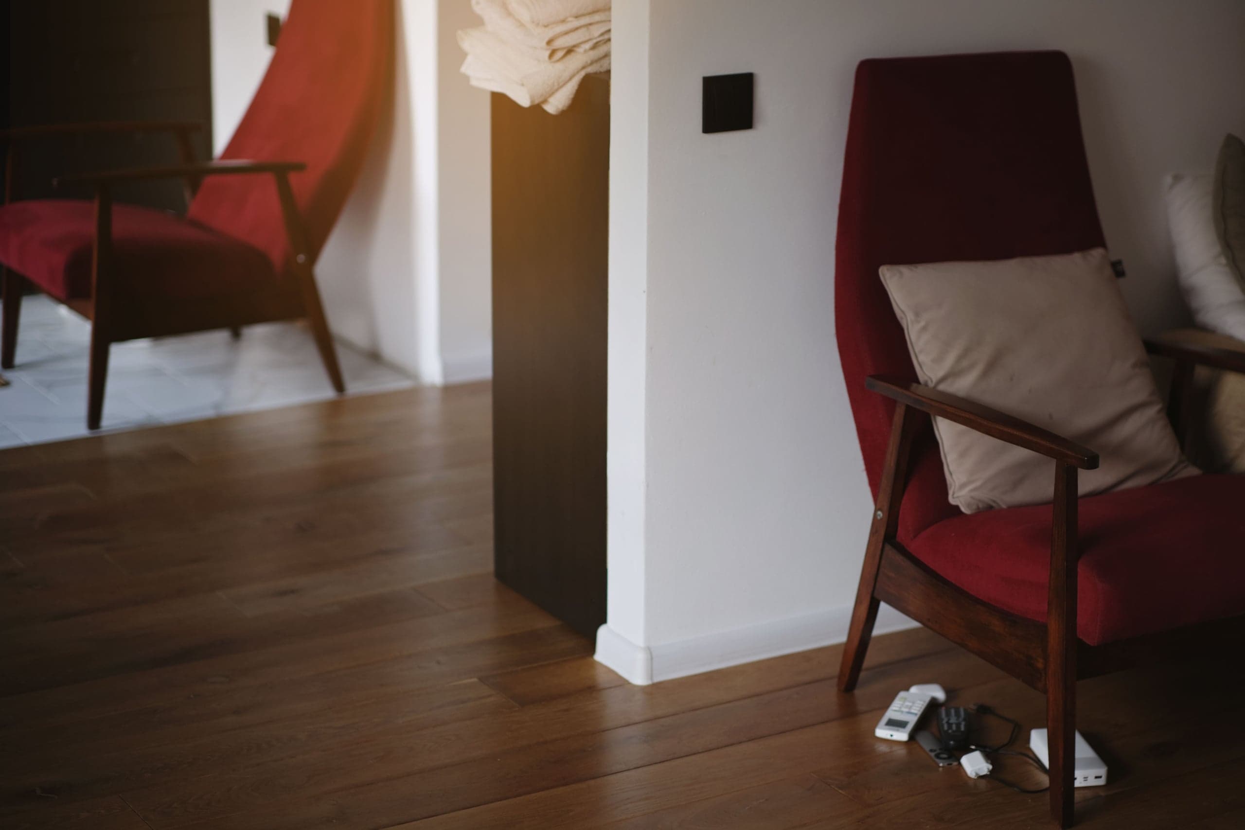 Séjour au parquet en chêne foncé, fauteuil rouge