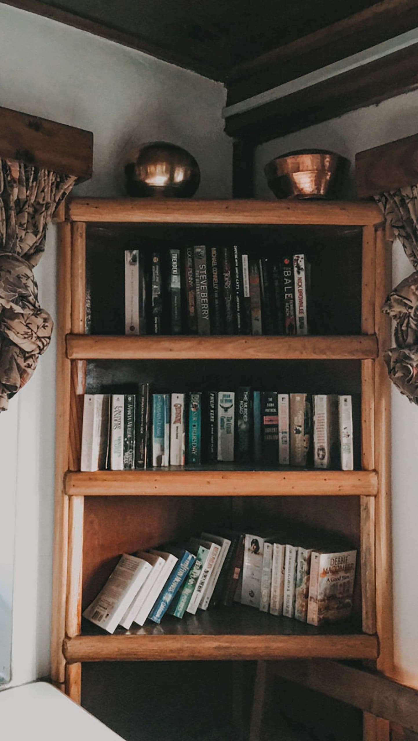 Bibliothèque ancienne en bois dans une pièce aux poutres apparentes